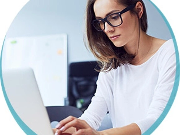 Młoda kobieta pracuje przed laptopem.